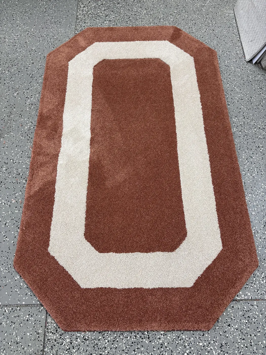 Custom-bound terracotta and cream rug made in the Enterprise Floors workroom