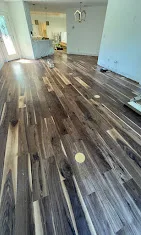 Multi-tone wood-look plank flooring mid-installation in a Naples home