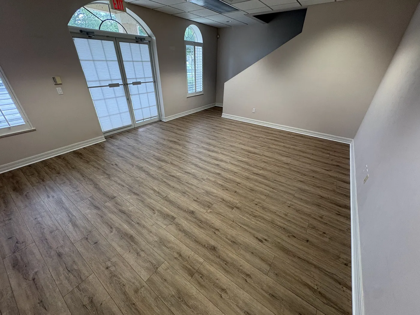Warm luxury vinyl plank flooring in a large Naples bonus room