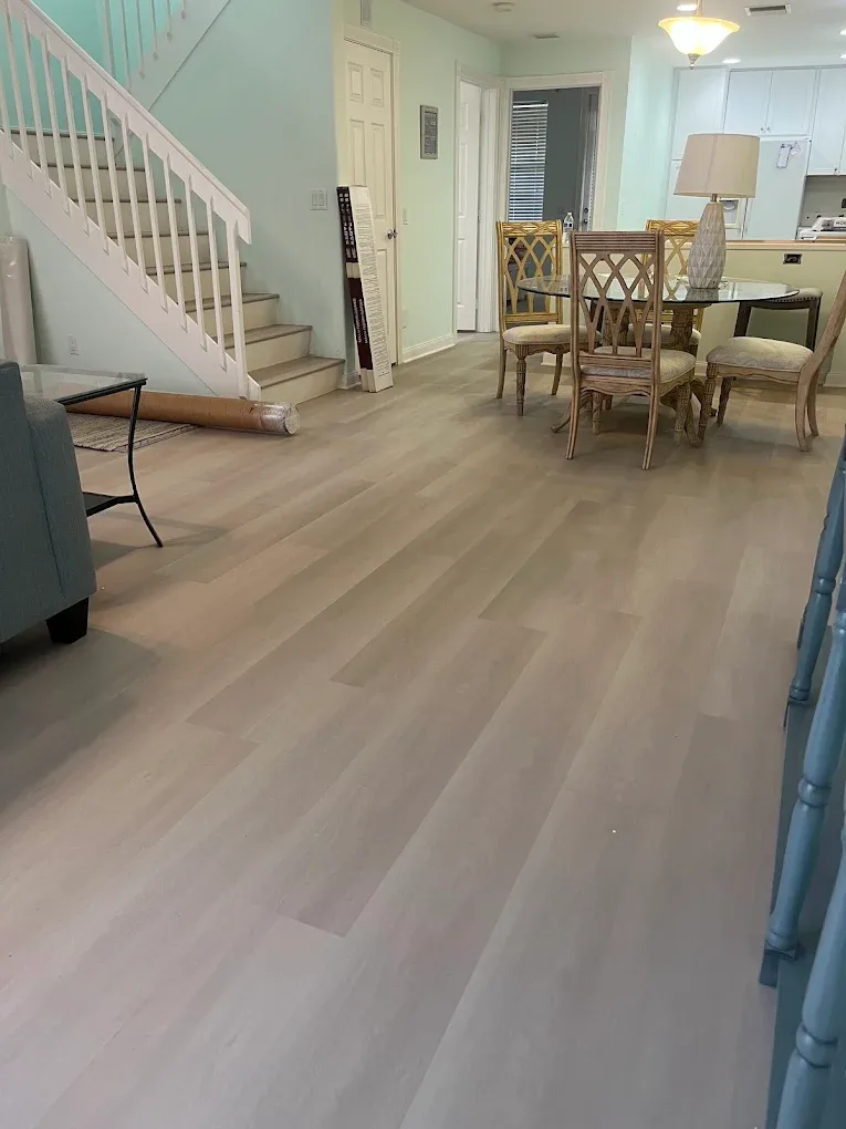 Light grey luxury vinyl plank flooring running through a Naples dining room and entry