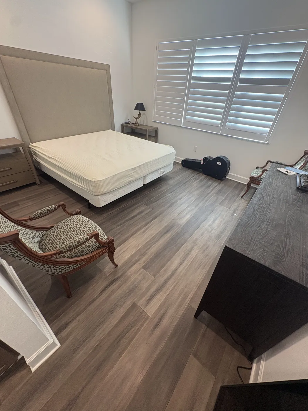 Grey-brown luxury vinyl plank flooring in a Naples primary bedroom