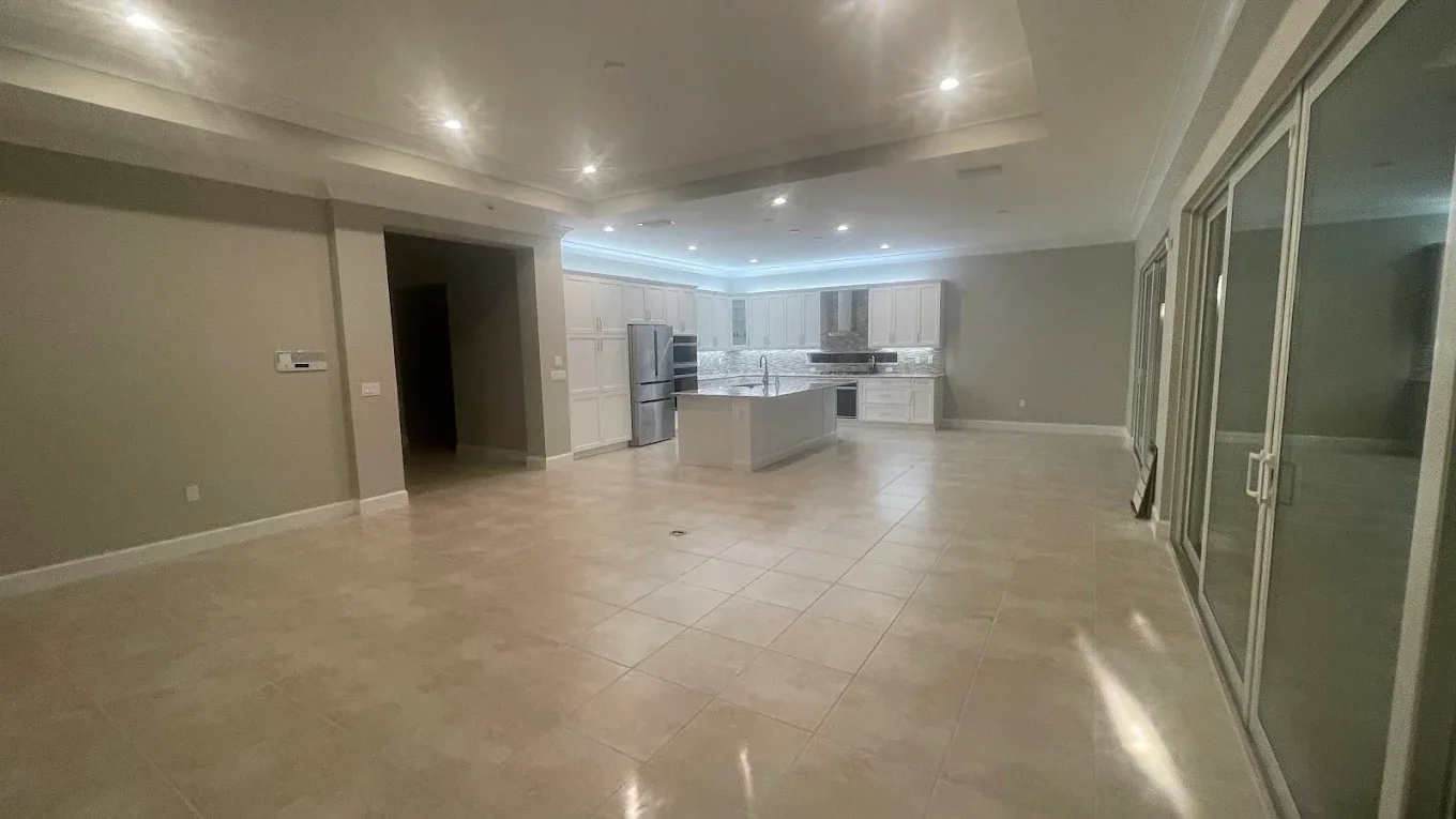 Large-format tile flooring in an open Naples great room and kitchen