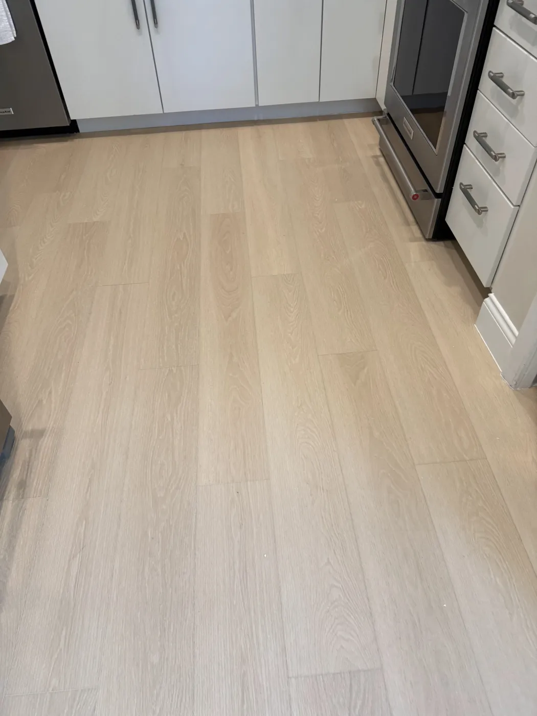 Pale white-oak plank flooring in a modern Naples kitchen